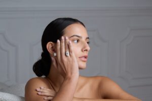 Anello solitario, mano al viso